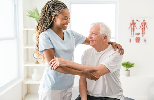 Caregiver helping elderly with daily exercise