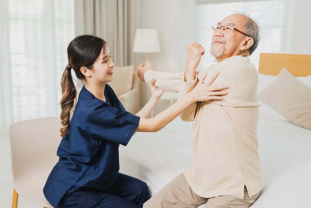 Social Worker helping Elderly exercise