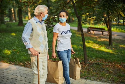 Social worker helping an elderly man with his groceries